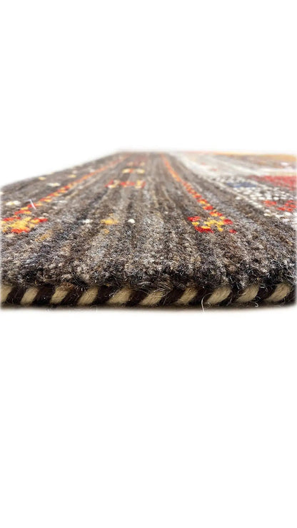 Gabbeh rug, close-up of the pile height at the rolled edge, dark with colorful accents