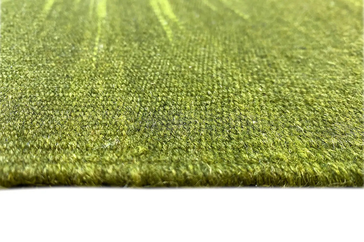 Green kilim rug close-up: dense wool fibers along the lower edge