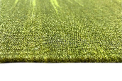 Green kilim rug close-up: dense wool fibers along the lower edge