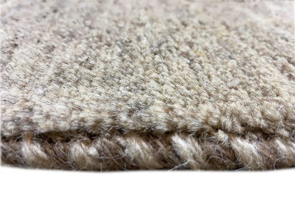 Gabbeh rug: dense high-pile weave in light beige with a visible rug edge.