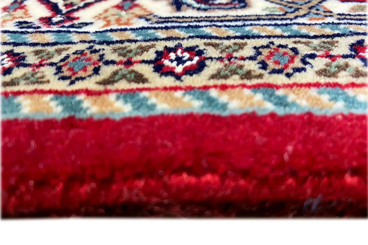 Carpet edge with red fringes and a blue-and-beige striped pattern, lower finish