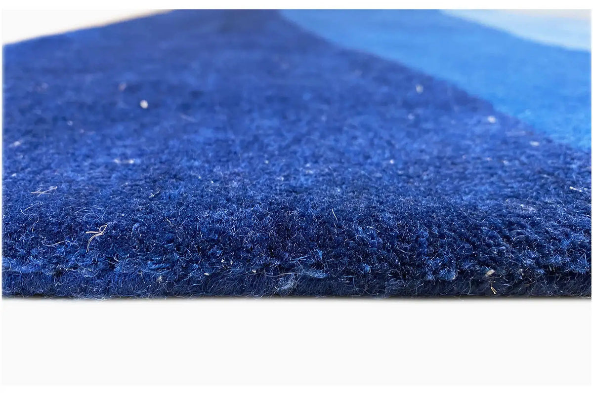 Close-up: blue carpet pile with a dense surface, hand-tufted
