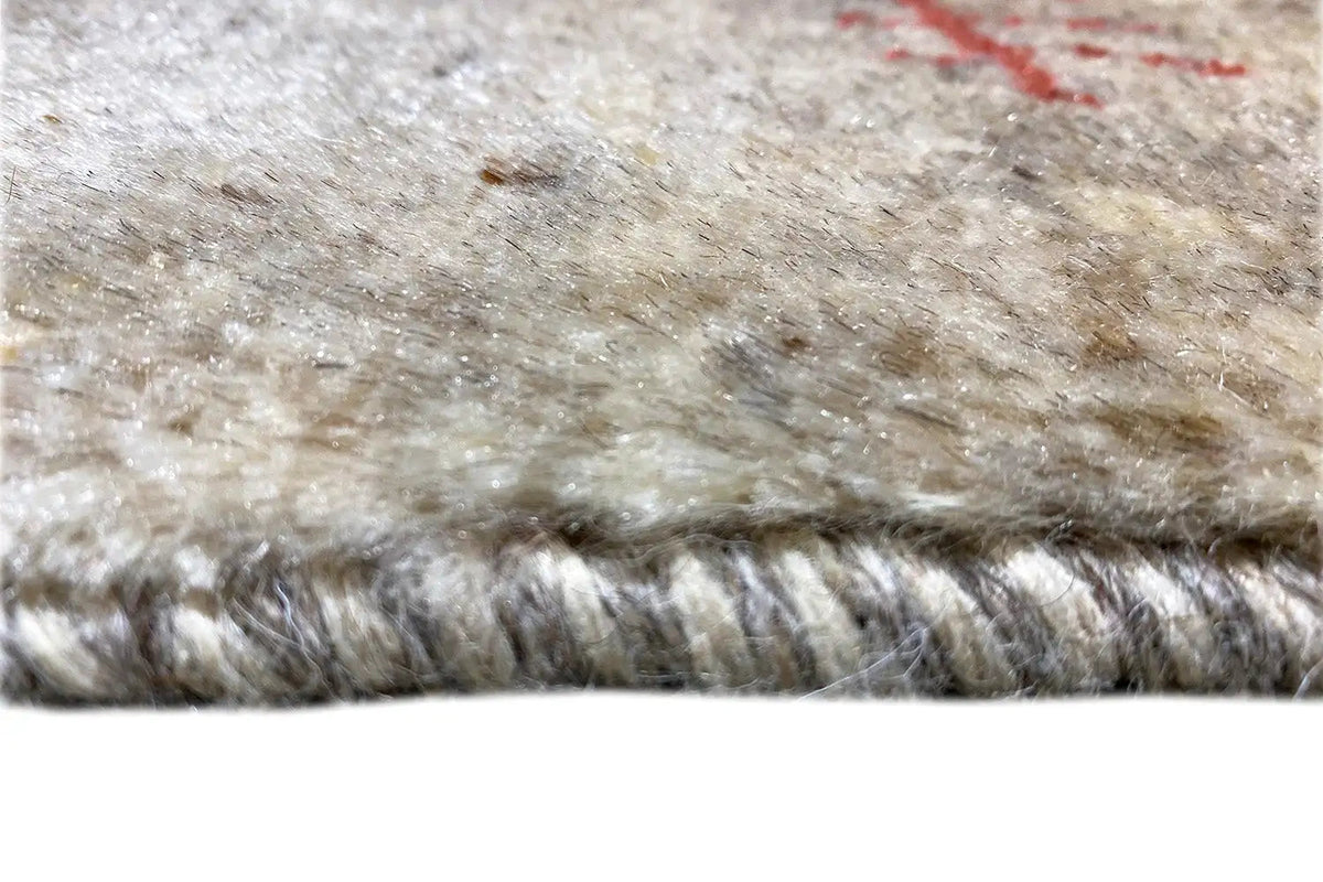 Gabbeh rug: Close-up of the beige wool pile and the wide fringed lower edge