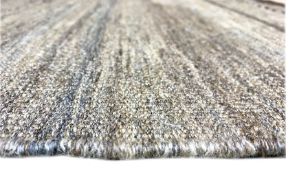 Kilim rug close-up: short woven pile texture in gray and beige tones, with fringes