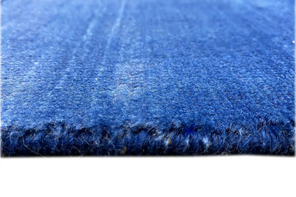 Close-up: blue rug with a dense pile and fringed edge