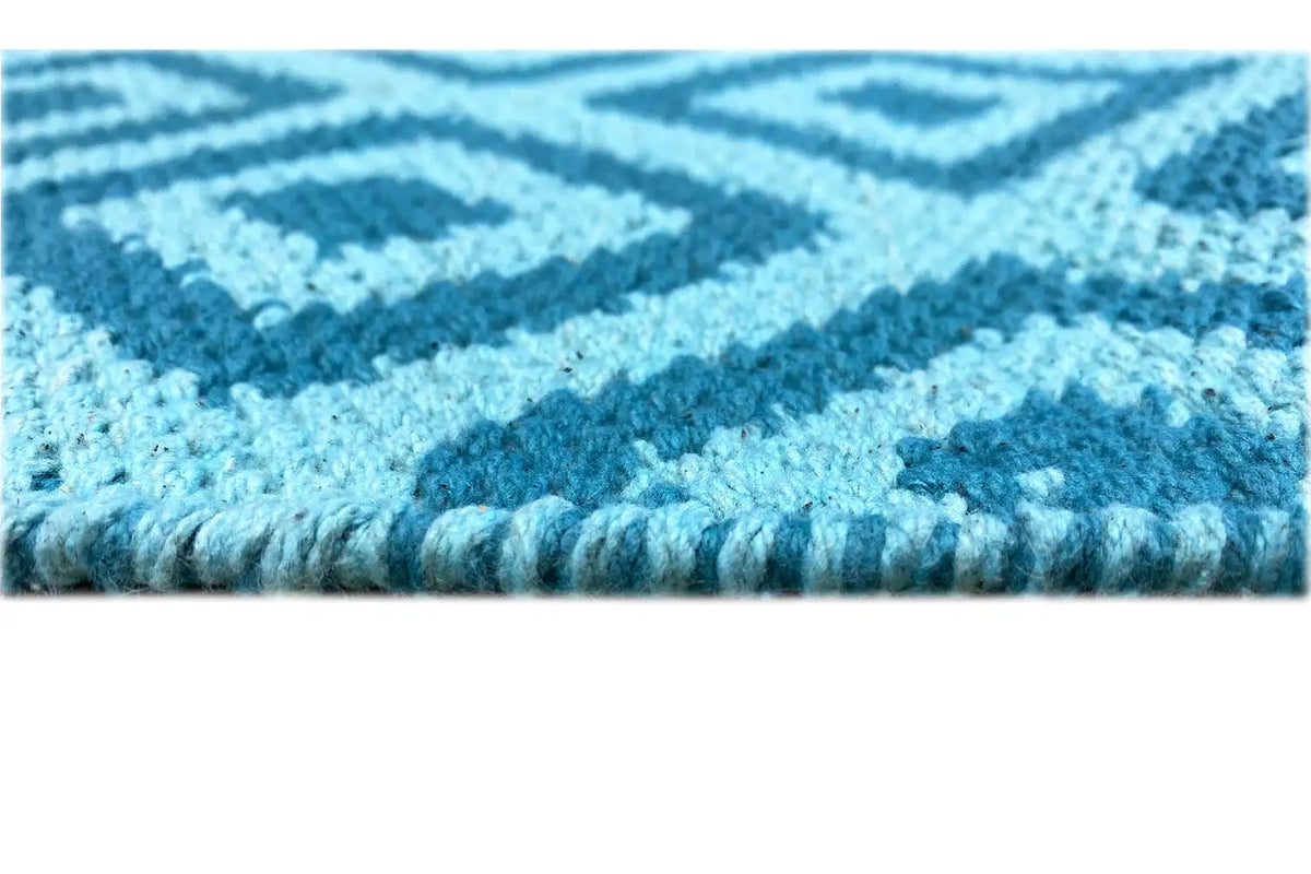 Close-up: blue kilim with a bound edge and visible weave structure