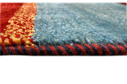 Gabbeh rug detail: fringed edge, blue with red and beige accents