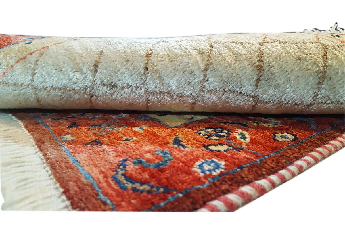 Carpet detail: rolled edge with beige pile, red border with ornamental motifs.