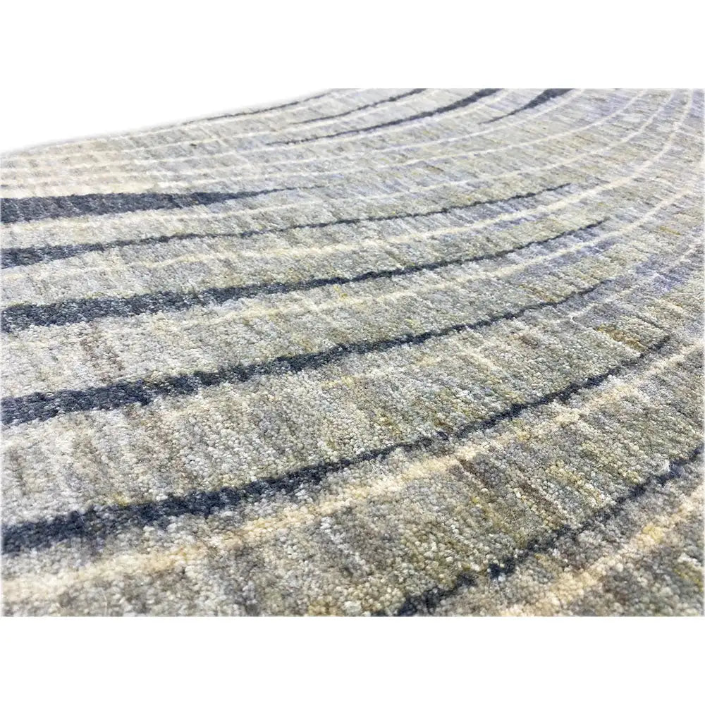 Close-up of a Gabbeh rug: beige pile with dark blue lines and a fine texture