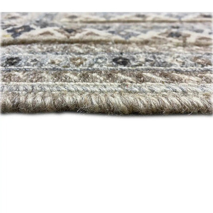 Close-up of pile height: blue-gray carpet with beige and dark raised details, short pile