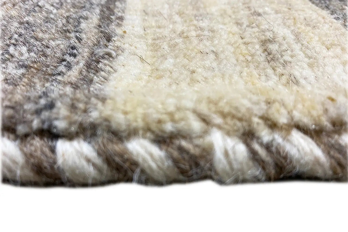 Gabbeh rug detail: dense pile in cream and dark gray, irregular shading