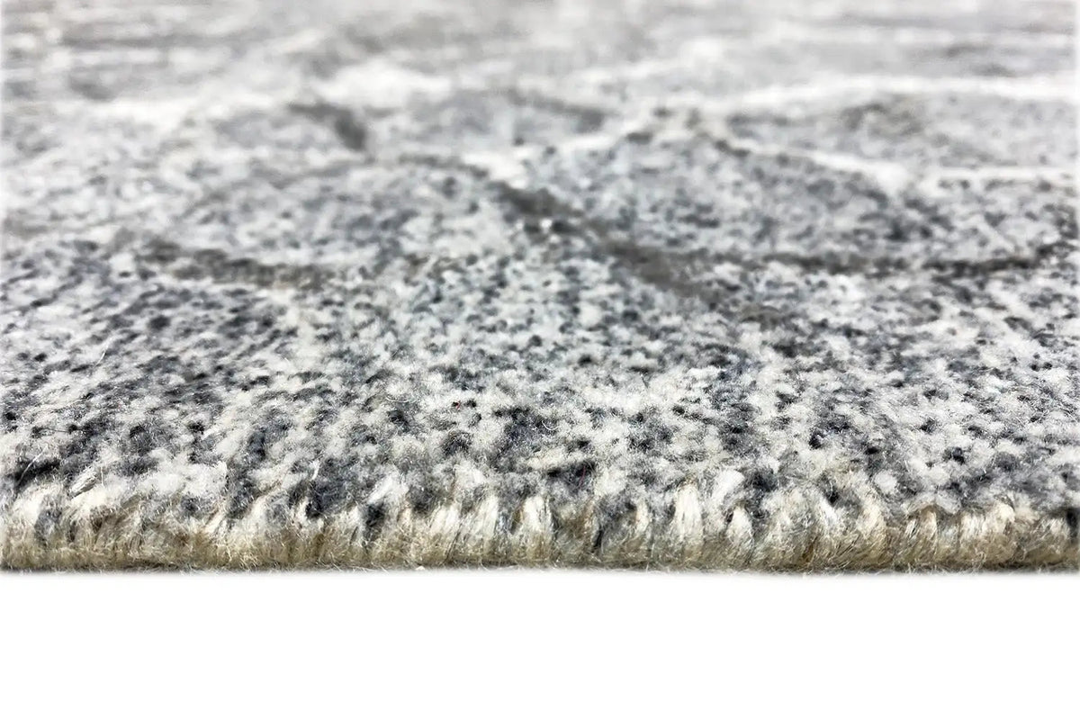 Hand-tufted rug, pile detail at the edge with a gray speckled pattern