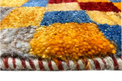 Gabbeh rug (190x83 cm), detail: dense pile in yellow, blue, and gray, with fringes along the edge.