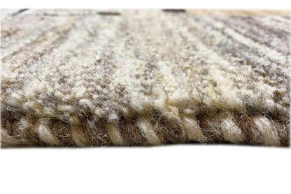 Rug edge with a dense, mottled pile texture in light beige and gray