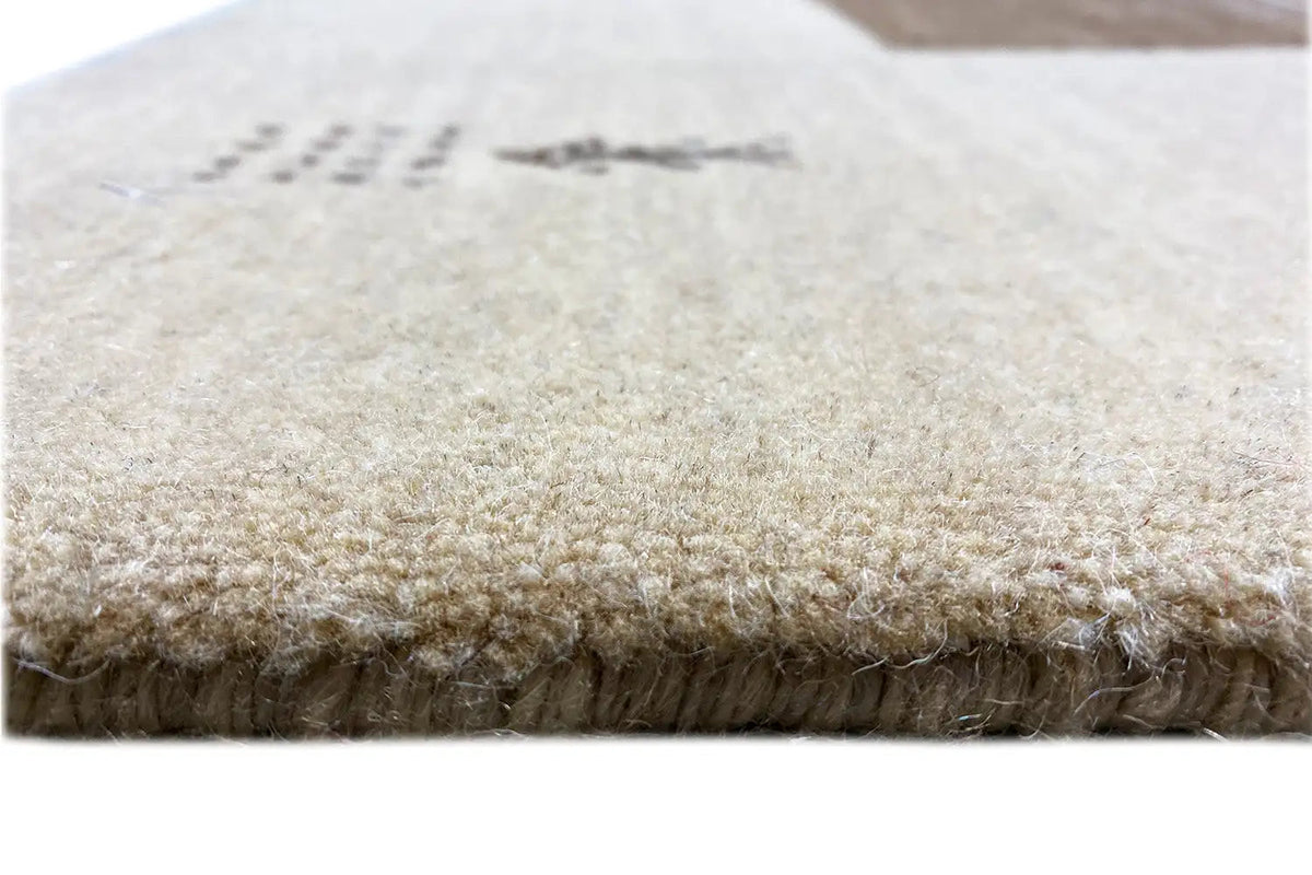 Gabbeh rug close-up, light beige pile with short fringe along the edge, 200x150 cm