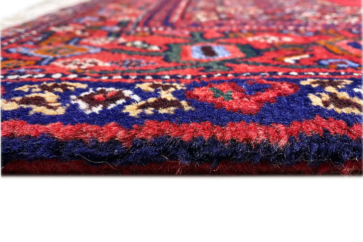 Hamadan rug close-up of the pile edge with red and blue fringes