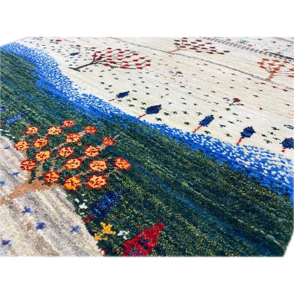 Close-up of a Gabbeh rug: tree garlands and patterns in red, dark green, and blue on cream
