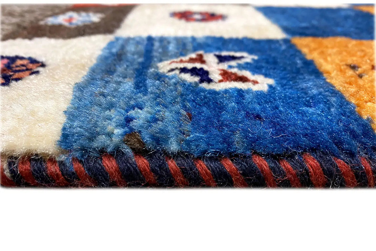 Gabbeh-Lori rug detail: blue pile fibers and red fringes along the rug's edge