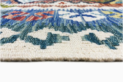 Close-up: Afghan kilim with a woven edge and cream-colored pile, blue patterns