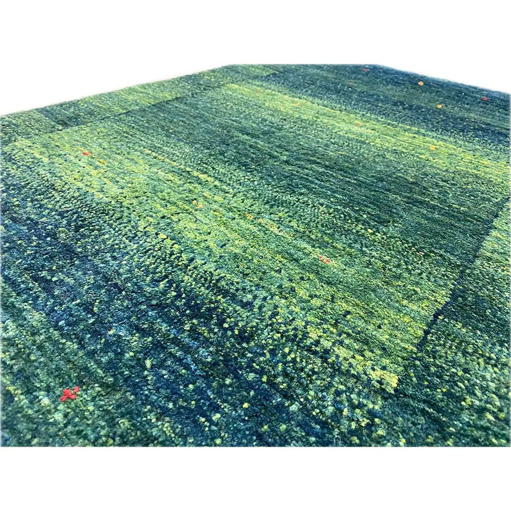 Lori Gabbeh rug: woven surface in green and blue with numerous colorful dots
