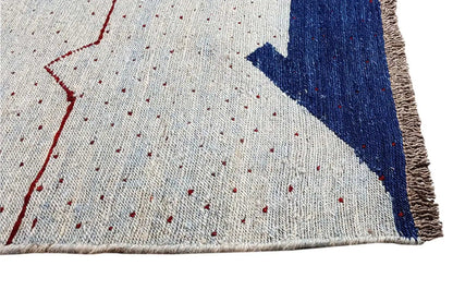 Kilim rug with a light background, blue corner, and red gradients, with fringes