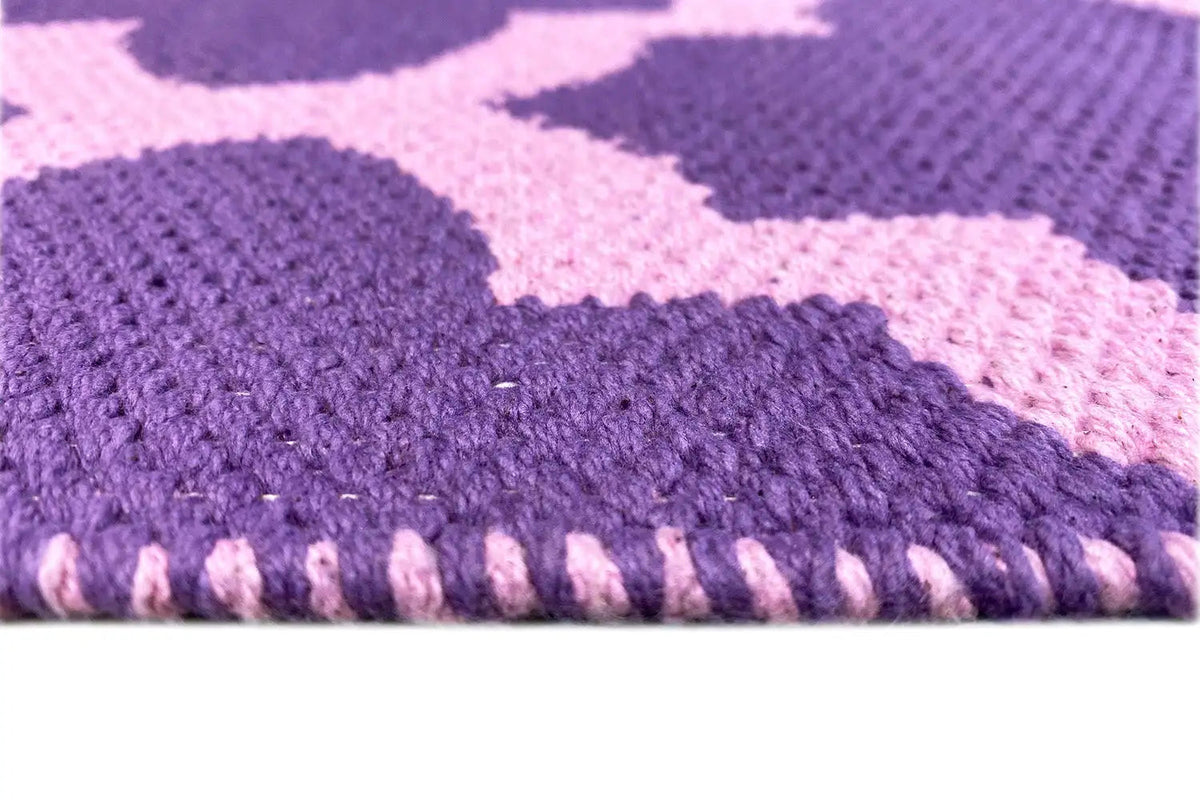 Rug with a visible edge seam and purple pile backing, fine weave texture in detail