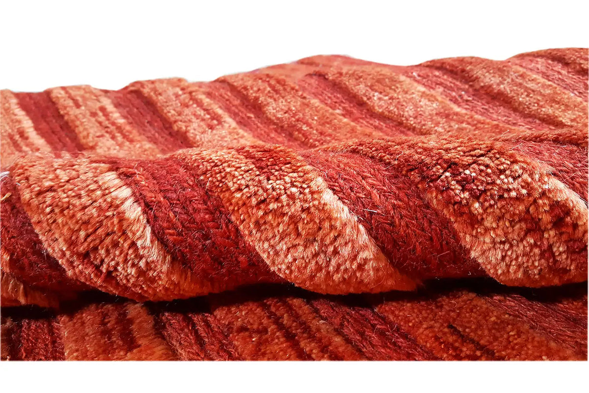 Gabbeh rug detail: braided pile in reddish brown with a uniform texture