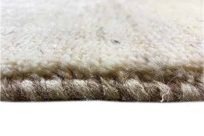 Close-up of a Gabbeh rug: dense beige pile with brown nuances at the edge