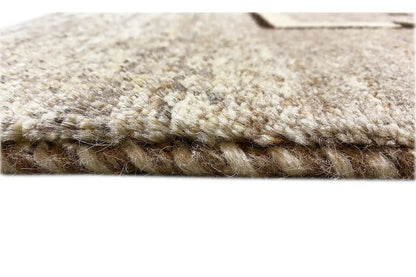 Close-up of the Gabbeh rug: dense pile and felted edge, light gray/cream