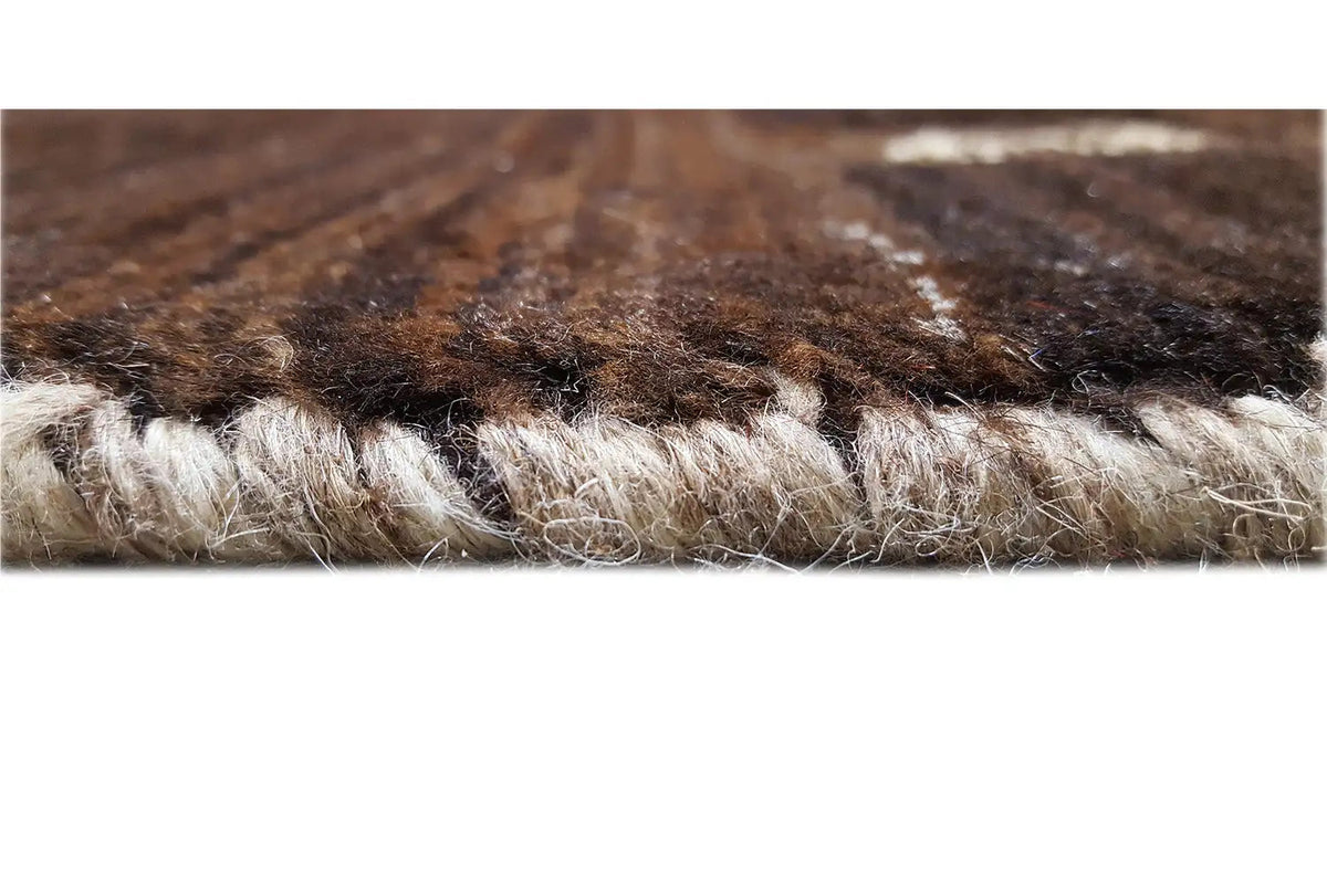 Close-up of the Gabbeh rug: dense wool fibers, brown-beige texture in the pile