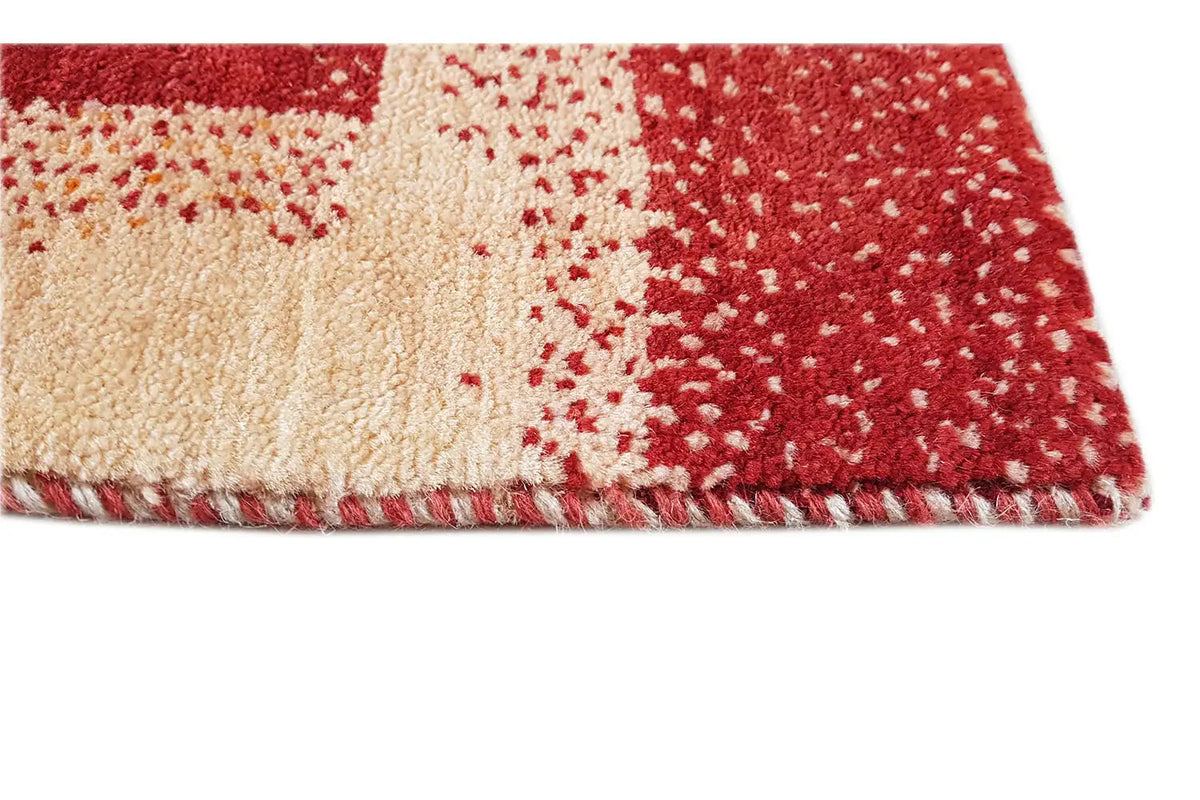 Gabbeh rug (89x60 cm) close-up: pile with fringe along the edge, red and beige