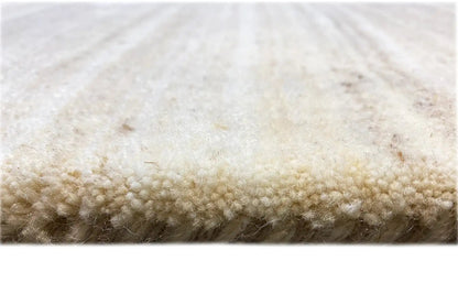 Rug edge: beige Gabbeh loom rug with a dense, short pile