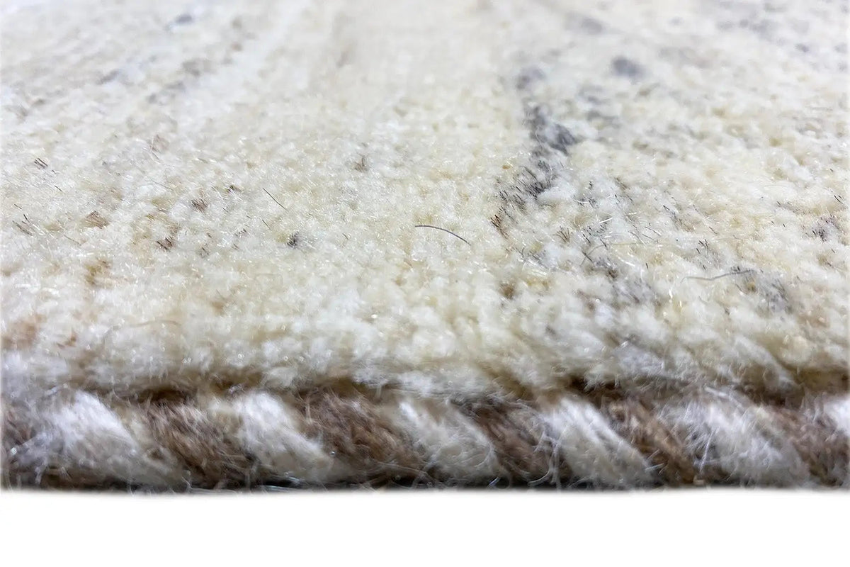 Carpet pile with a short, beige surface and dark spots around the edges