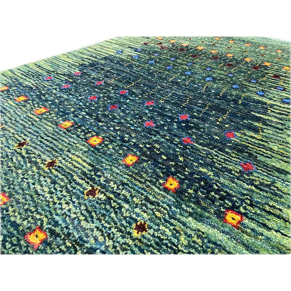 Gabbeh rug Lori detail view: green area with multicolored patterned dots and lines