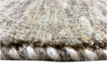 Gabbeh rug close-up: soft pile and fringed edge in gray and cream