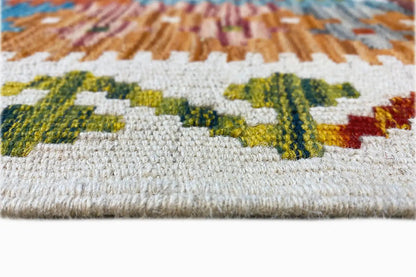 Afghan kilim close-up: woven pile with colorful ornaments along the edge