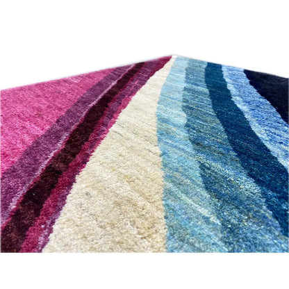 Gabbeh rug detail with diagonal stripes in pink, cream, and blue