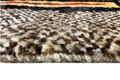 Rug pile in detail: woven texture in beige, brown, and dark tones on a light background.