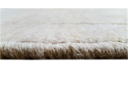Close-up of a Gabbeh rug: beige pile with short fringe along the edge