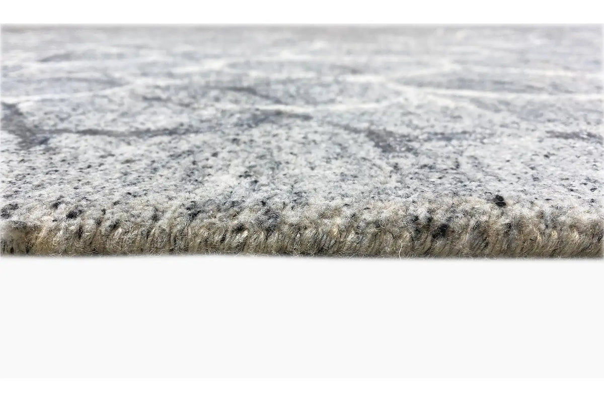 Hand-tufted rug, side view: dense pile with a woven edge