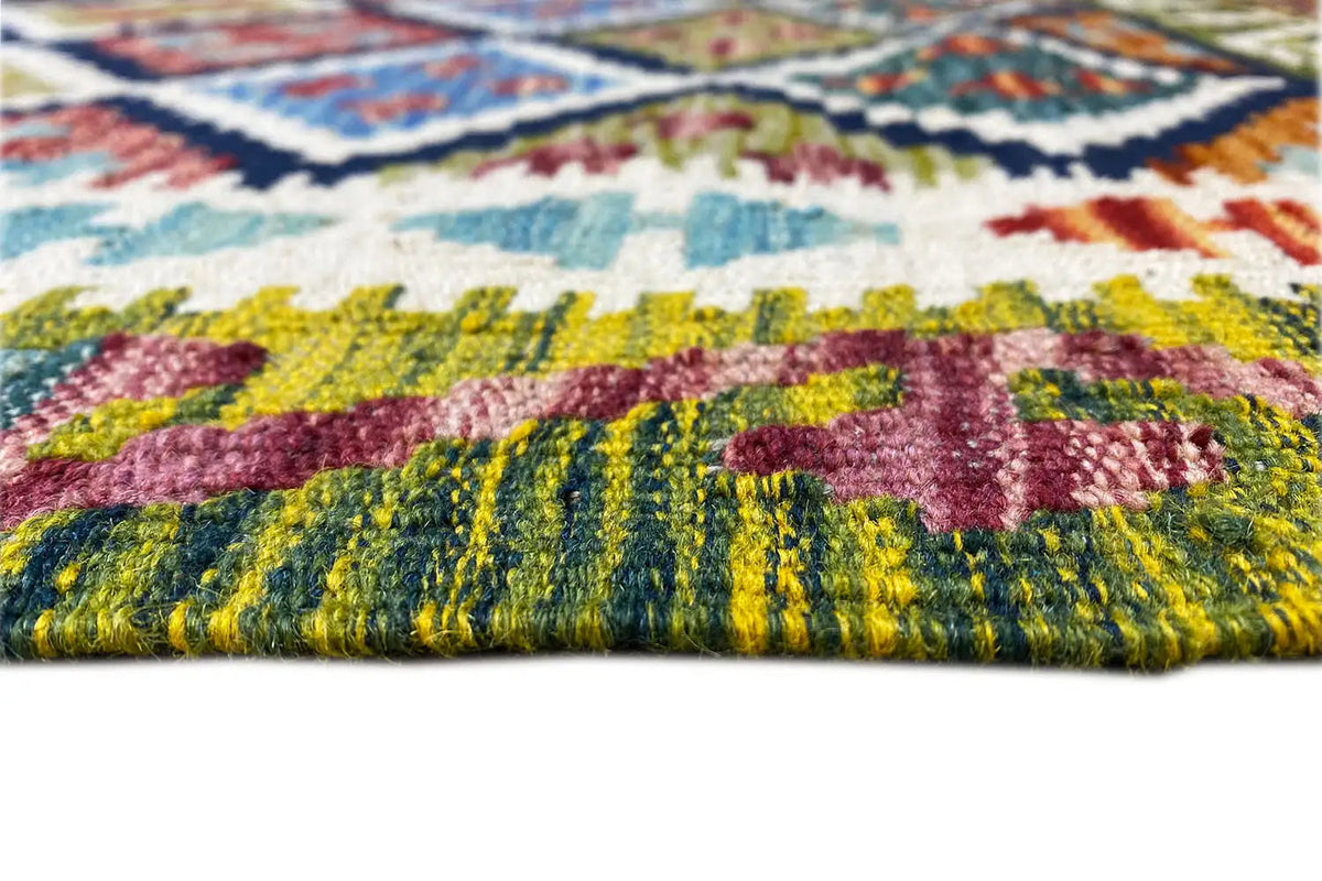 Close-up of a kilim runner: multicolored woven texture and short fringes along the edge