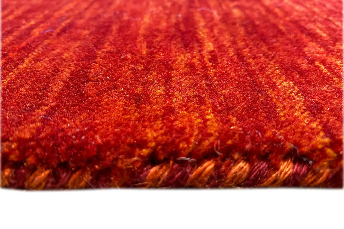 Gabbeh rug with a dense pile and visible backing at the edge, close-up