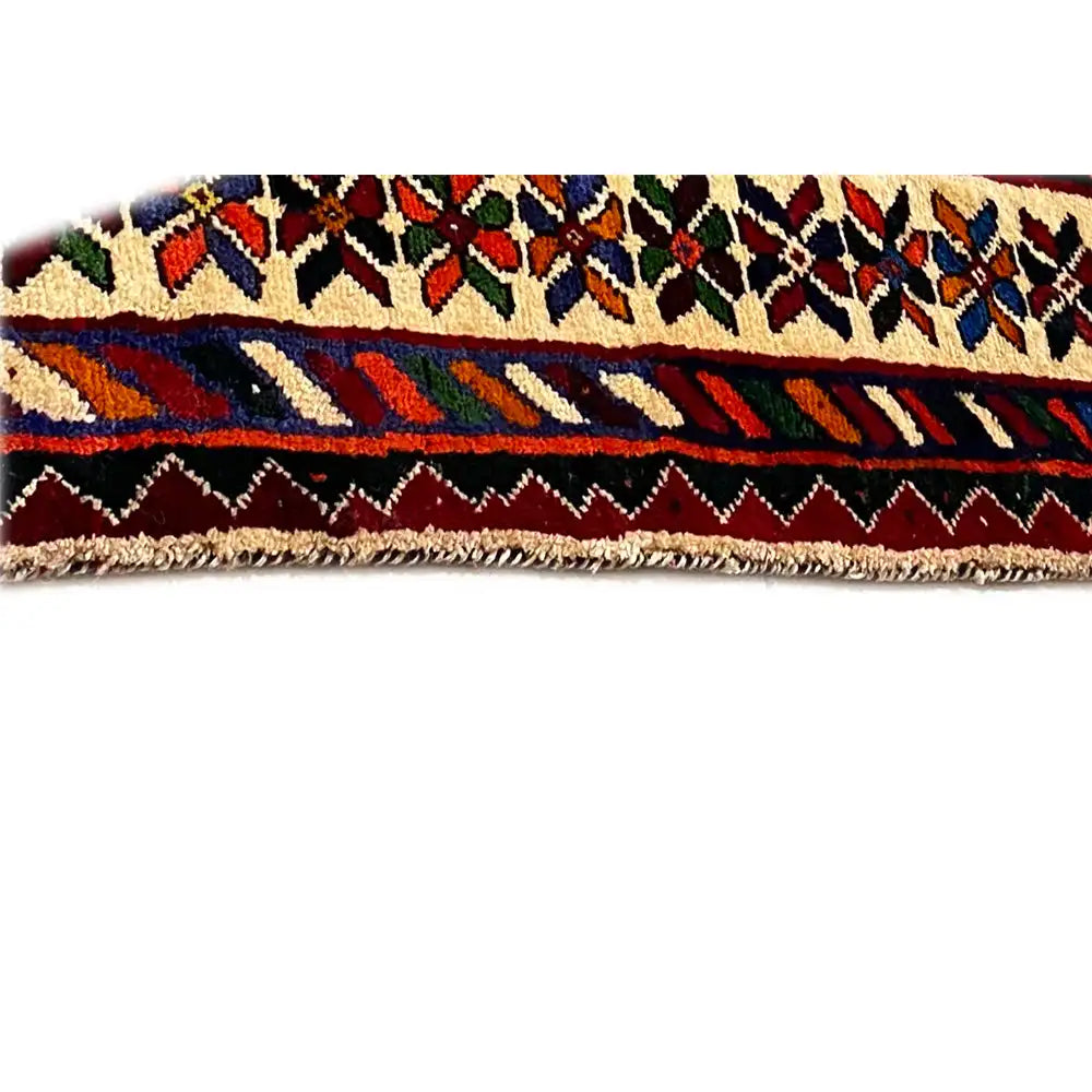 Close-up of the selvedge of a Shiraz carpet with fringes and a colorful striped pattern