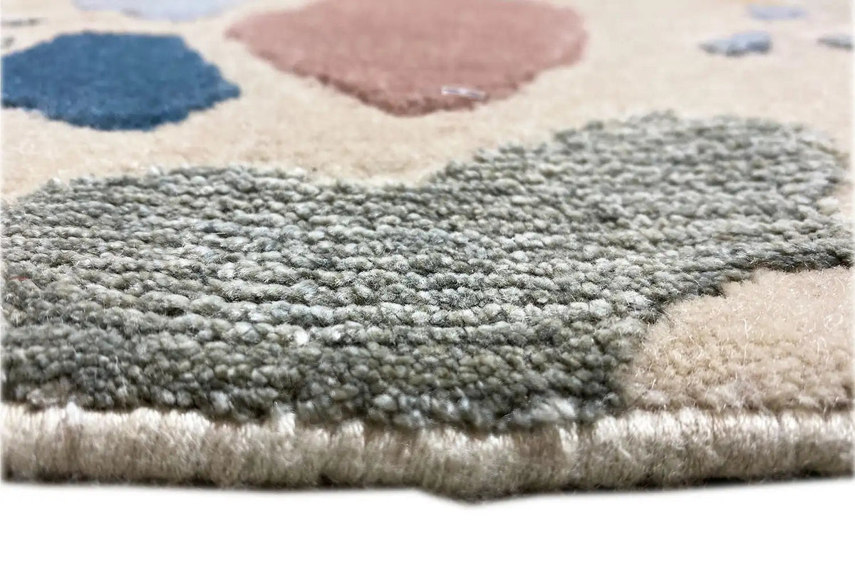 Close-up of the carpet pile and edge, dense pile in gray, blue, and beige