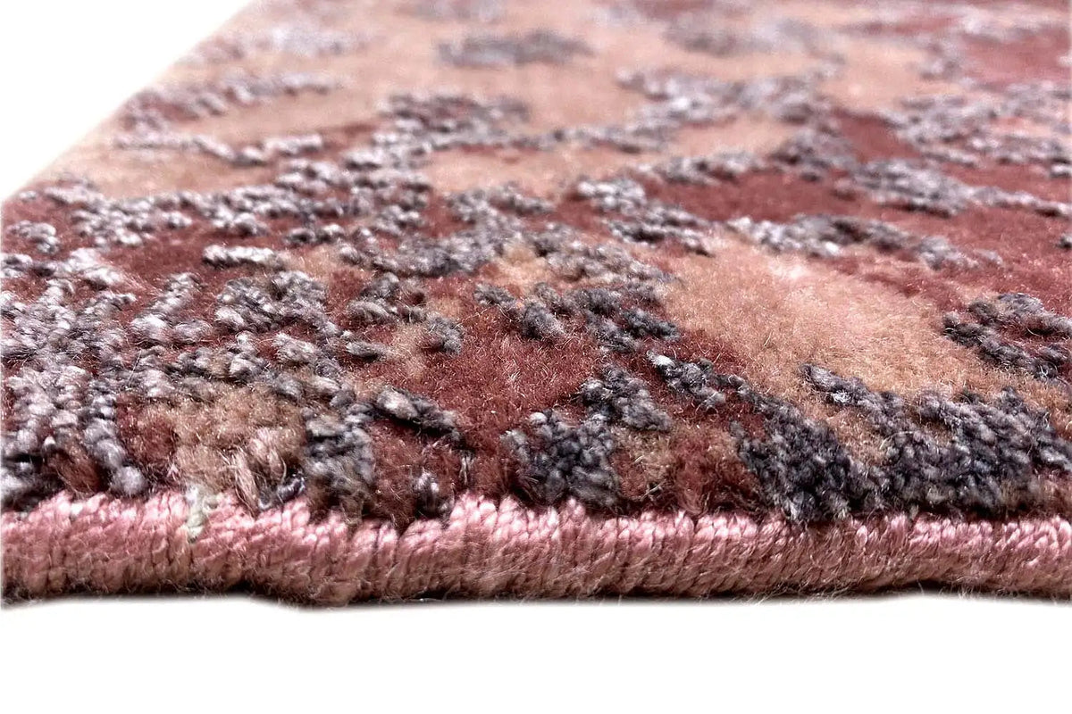 Designer rug: close-up of the pile edge, mottled pattern in burgundy and beige