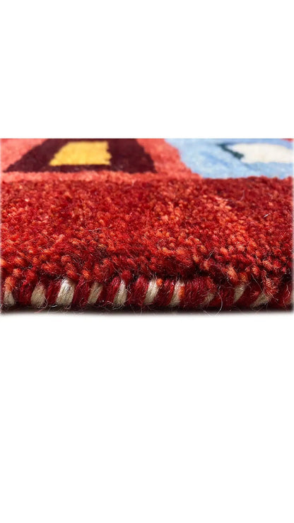 Gabbeh rug (200x151 cm), close-up: pile and fringe along the edge, patterned in red and blue.
