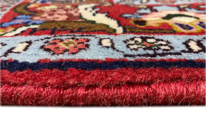 Hamadan carpet edge view with a red pile and white fringes.