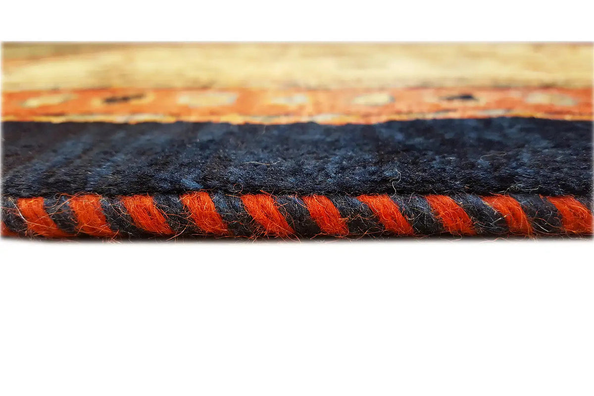 Carpet edge with dense decorative fringe in black and orange, border detail