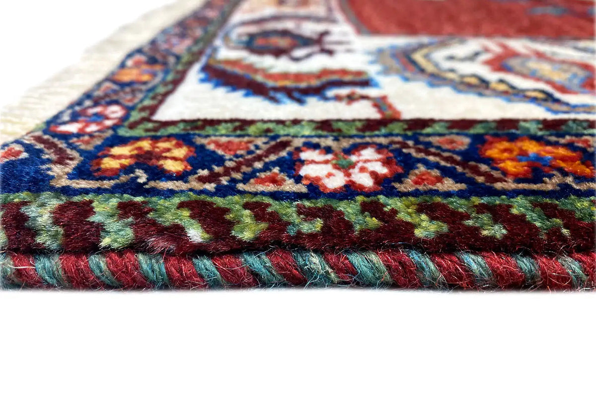 Carpet edge with fringe and a colorful floral pattern in the woven pile