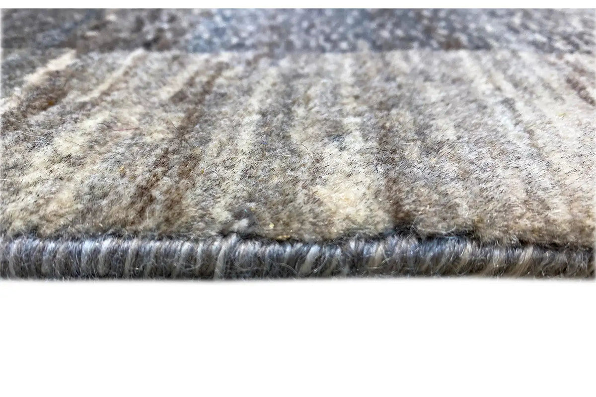 Gabbeh Lori rug: fringed edge and mottled light gray-beige surface